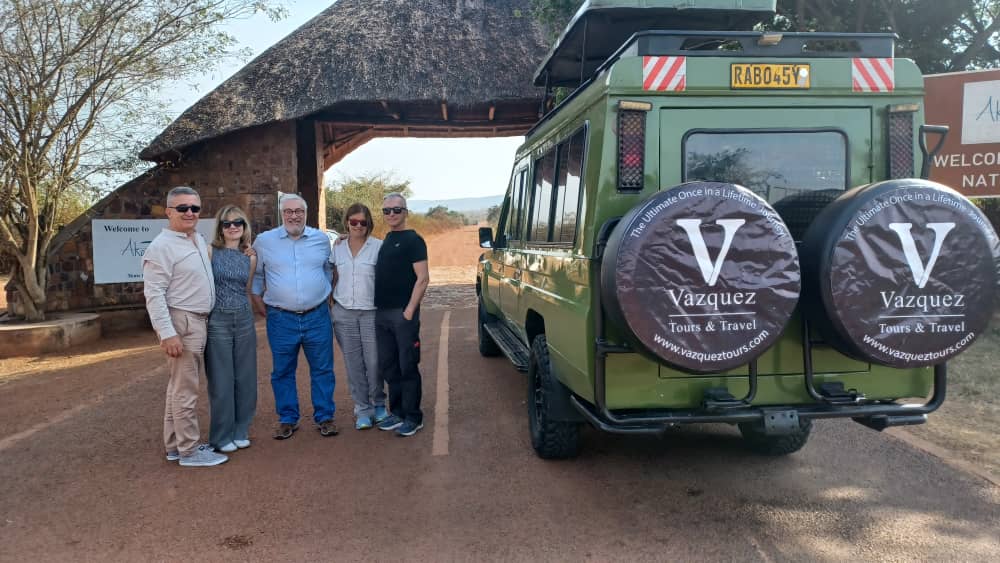 Vazquez Tours guests beside a safari vehicle in Rwanda